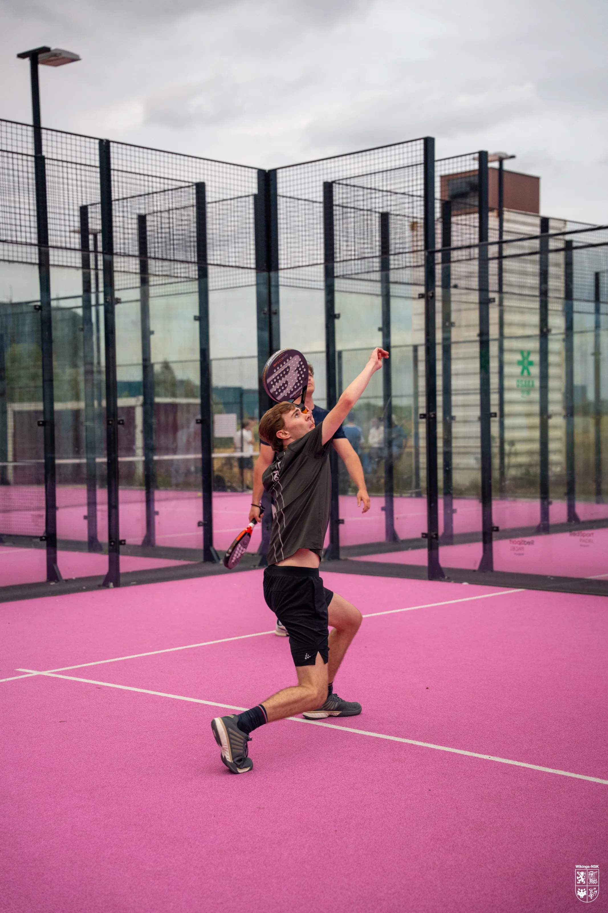 Padelspeler slaat een smash op een roze terrein