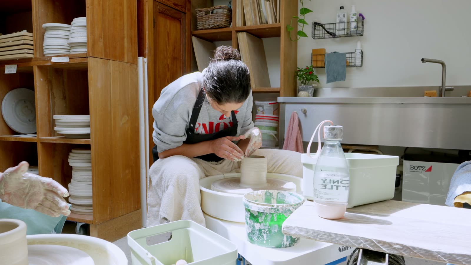 Lies Bulteel throwing a piece at the pottery wheel in her atelier