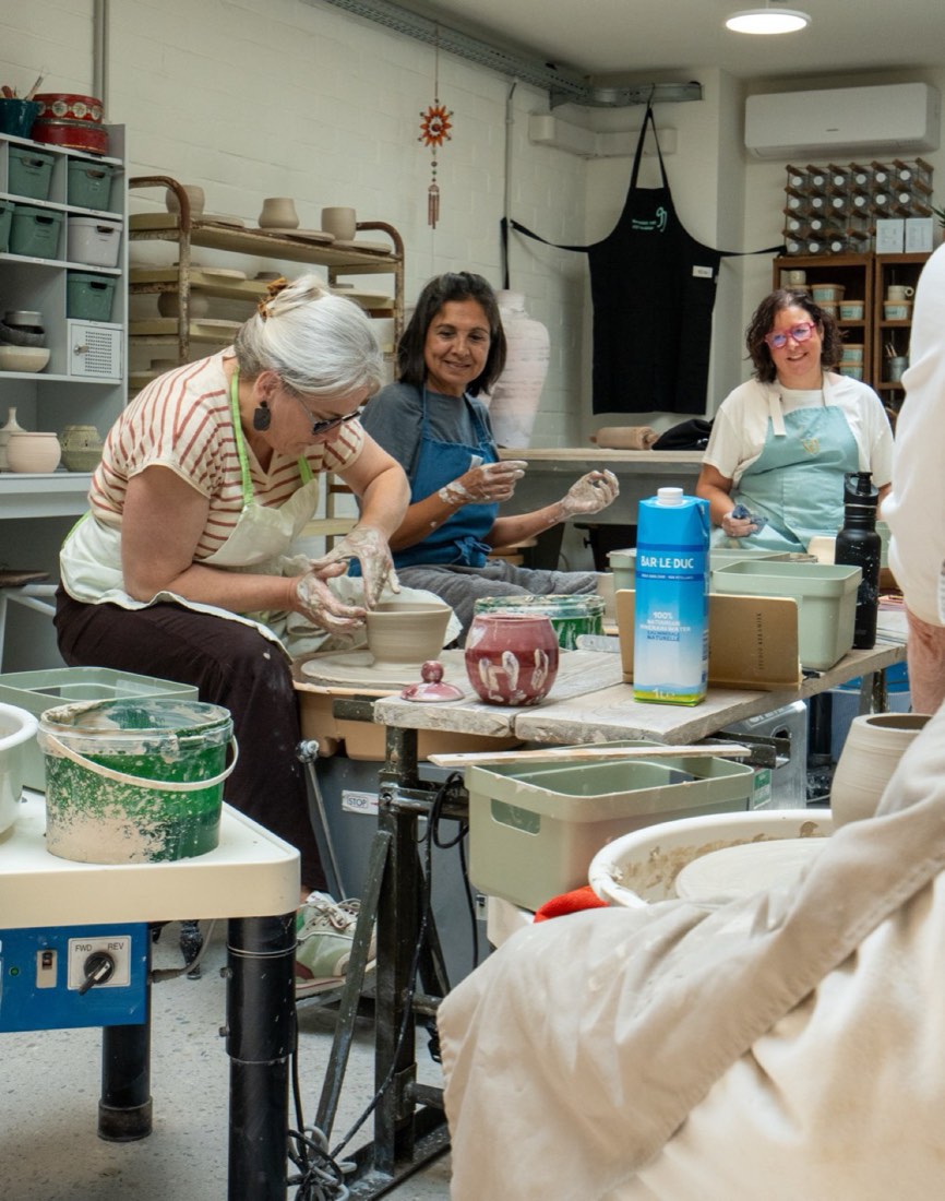 Workshop participants at the pottery wheels in the atelier