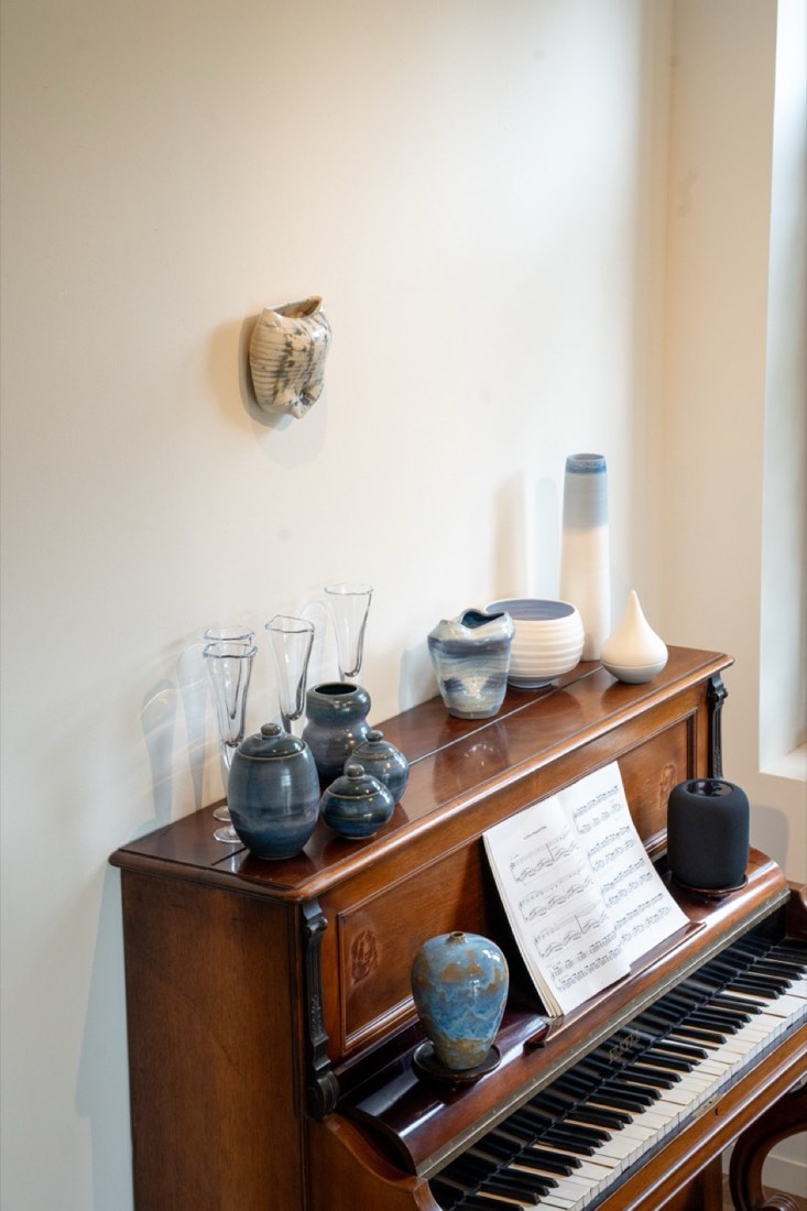 Ceramic vases and jars displayed on an antique piano