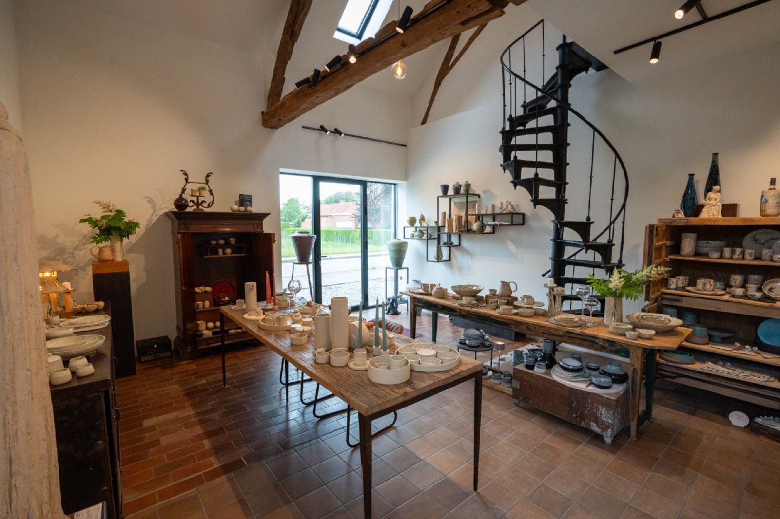 The shop interior with its spiral staircase and tables full of handmade ceramics